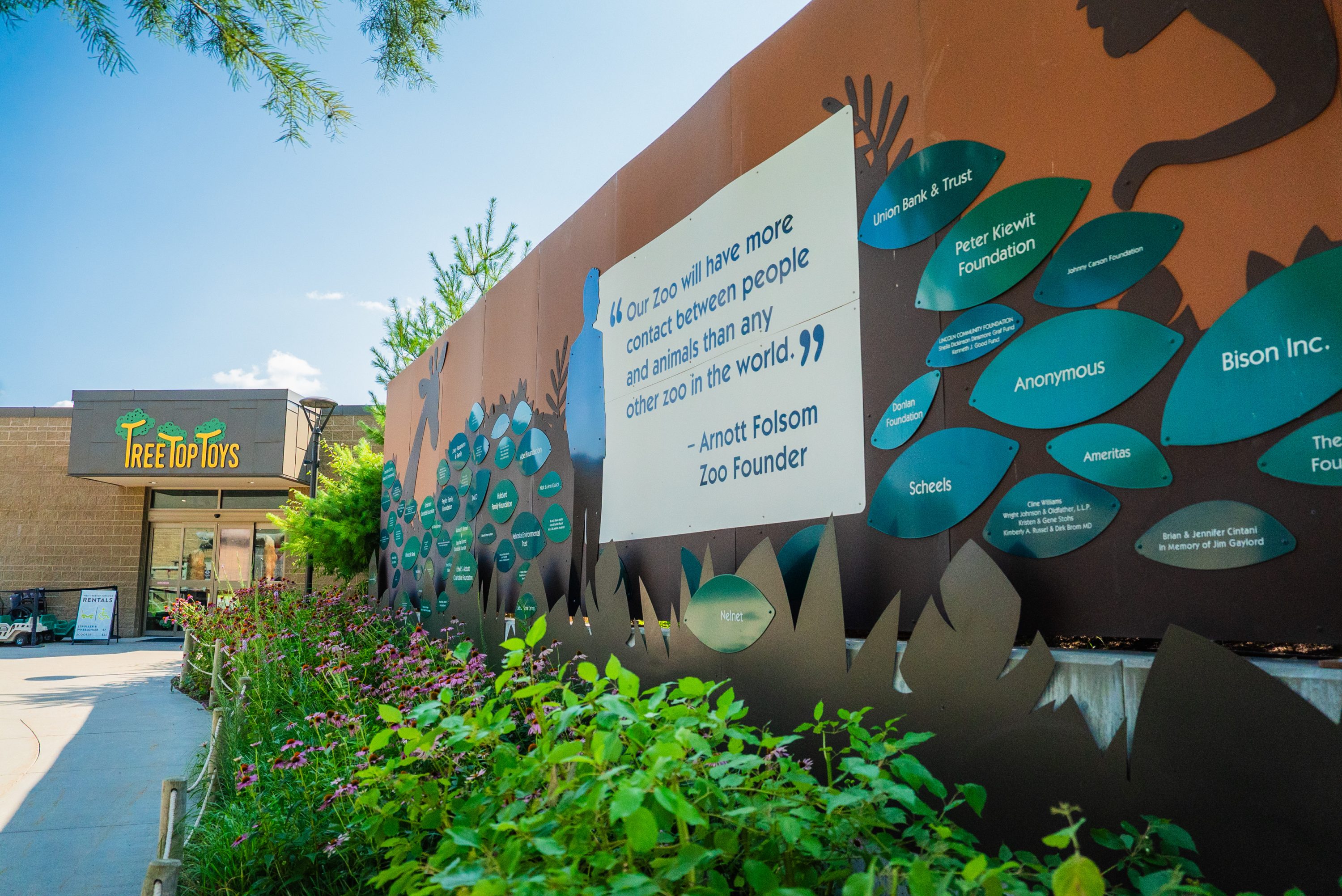 Lincoln Childrens Zoo Donor Wall with metal decorations such as leaves with each donors name and zoo animals.